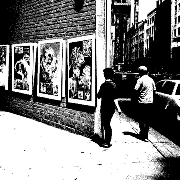 A city street corner with posters displaying a series of street art illustrations