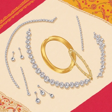 An assortment of bridal jewelry is displayed on a textured traditional fabric backdrop. The collection includes a glittering diamond necklace with intricate designs, sparkling earrings that dangle elegantly, and a delicate tiara adorned with shimmering gemstones. A pair of ornate bangles, crafted from gold, sits elegantly alongside the necklace. The fabric backdrop features rich colors and patterns that complement the jewelry, enhancing the overall presentation of the stunning pieces.