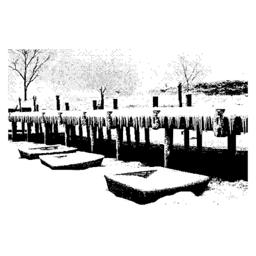 A boat dock is covered in a thick layer of snow. The wooden pier is lined with long icicles that hang down, glistening in the light. Empty boats are tied to the dock, partly buried under the snow. The surrounding water is frozen, with a smooth surface reflecting the snowy scene. Sparse trees in the background are adorned with a dusting of white snow. The atmosphere conveys a sense of stillness and tranquility.