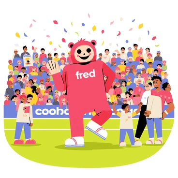 Fred the Red, the Manchester United mascot, is standing on the pitch, wearing his bright red costume with a large smiling face. He is waving enthusiastically to a crowd of fans in the stands, some holding banners and flags. The stadium is bustling with excitement, and colorful confetti is flying through the air. Fred is performing a playful dance, surrounded by children who are laughing and cheering. The atmosphere is lively, filled with team colors and the anticipation of the upcoming match.