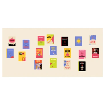 A gallery wall featuring a variety of colorful book covers. The book covers include bold designs with vibrant colors, each showcasing different art styles and typography. Some book covers are arranged in a grid pattern, while others are placed at different angles for visual interest. The wall has a light-colored background that enhances the vividness of the book covers. A few small frames surround the covers, adding a touch of elegance to the display.