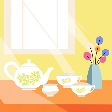 A delicate tea set featuring white porcelain with intricate "emerald patterns" is arranged neatly on a polished "wooden table." The tea set includes a teapot with a curved spout, two matching teacups, and a small sugar bowl. Sunlight gently illuminates the patterns on the tea set, highlighting the vibrant green against the white background. A small vase with colorful flowers is placed beside the tea set, adding a touch of color to the scene.