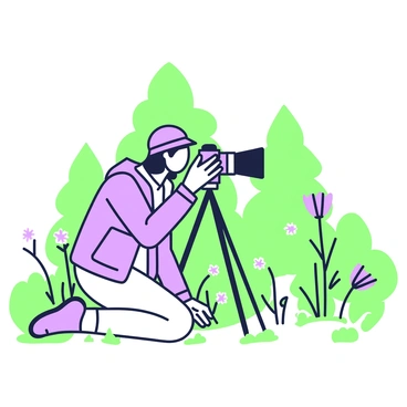 A photographer is kneeling on the ground, concentrating through the camera lens during a nature photoshoot. They are wearing a light jacket and a hat, with a camera mounted on a tripod in front of them. The surrounding area is filled with vibrant greenery, including leaves and grass, while small wildflowers peek through the foliage. In the background, there are tall trees framing the scene, and the soft natural light enhances the tranquil atmosphere. The photographer's focused expression shows their dedication to capturing the moment.