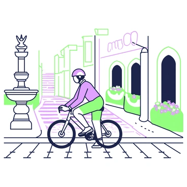 A cyclist is carefully riding over a cobblestone street in an old city area. The street is lined with historic buildings featuring ornate architecture. To the left, there is a stone fountain with a carved figure at its top. On the right, there are flower pots with colorful blooms placed along the edge of a building. The cyclist is wearing a helmet and a fitted cycling outfit. Shadows from the buildings stretch across the cobblestones, creating a dynamic interplay of light and dark. 