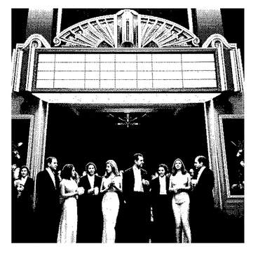 A classic art deco theater is prominently displayed with its ornate marquee shining. A group of moviegoers, including men in suits and women in elegant dresses, is eagerly entering the theater. The crowd is diverse, with individuals of varying ages and ethnicities. Some attendees are holding popcorn and drink cups, while others are chatting excitedly. The entrance features tall, stylized doors and intricate geometric patterns typical of art deco design. The atmosphere is lively, capturing the anticipation of a cinematic experience.