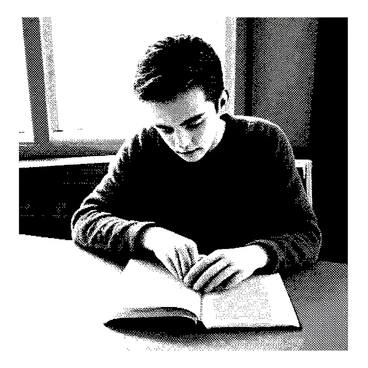 A person is sitting at a wooden table, deeply engaged in reading a book. Their eyes are focused, glancing over the pages with intent. The book is open in front of them, displaying printed text that is partially visible. The person's hair is styled neatly, and they wear a comfortable sweater. Light from a nearby window illuminates the scene, casting soft shadows on the table.