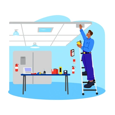 A technician wearing a blue uniform is adjusting a fire alarm system inside a modern building. The technician is standing on a step ladder, reaching up to a ceiling-mounted alarm unit. Various tools, including a multimeter and a screwdriver, are displayed on a nearby workbench. Bright lights illuminate the spacious room, and several smoke detectors and fire extinguishers are visible along the walls. The technician has a focused expression as they examine the system's wiring and settings.