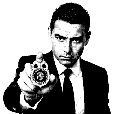 A detective with short, slicked-back hair is holding up their badge in a confident manner. The badge is prominently displayed in front of them, gleaming under the light. The detective has an intense expression on their face, with slightly furrowed brows and focused eyes. Their attire consists of a dark suit and a white shirt, with a tie that complements the overall look. The background is out of focus, providing emphasis on the detective and the badge.