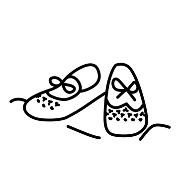 A pair of tiny shoes is positioned on a soft surface. The shoes are adorned with intricate lace patterns, showcasing detailed designs that enhance their delicate appearance. The shoes are small, emphasizing their suitability for a baby. The overall presentation highlights the shoes' elegance, suitable for a baptism outfit.