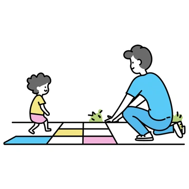 A parent is kneeling down on a regular sidewalk, carefully placing colorful, cushioned mats to create a soft path for a child. The parent is wearing a blue shirt and jeans, focused on arranging the mats in a straight line. A small child, with curly hair, is standing a few steps away, looking excited and ready to walk on the new path. The sun is shining, casting gentle shadows on the ground, and there are a few green plants visible along the sidewalk's edge.