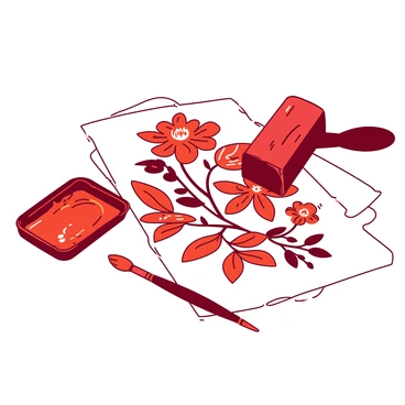 A red block printing tool is positioned above a white medium-sized sheet of paper that has intricate floral patterns printed on it. The floral designs are bold and feature a variety of flowers, leaves, and vines, all showcasing a harmonious arrangement. Nearby, there is a small tray filled with orange ink, with a paintbrush resting against it, ready for additional applications. The scene is well-lit, highlighting the texture of the paper and the vivid details of the patterns.