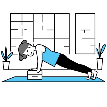 A person performing a pike push-up in a yoga studio. The individual, dressed in a light blue tank top and black yoga pants, is positioned with their feet elevated on a yoga block, arms supporting their body on a mat. The studio features large windows that let in natural light, illuminating wooden floors and minimalist decor. A few potted plants are placed around the space, adding a touch of greenery.