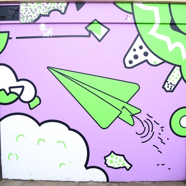 A paper plane painted as part of a vibrant street art mural