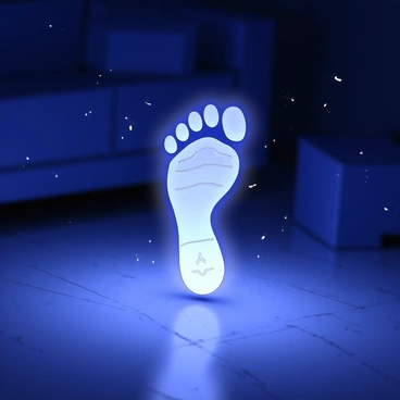 A single holographic footprint is displayed in the center of a dimly lit room. The footprint appears three-dimensional, with intricate details of the sole visible, including tread patterns and contours. The surroundings are shadowy, with indistinct shapes of furniture barely discernible in the background. The glow from the footprint emanates a soft light, casting faint reflections on the floor. Dust particles are floating in the air, highlighted by the holographic projection.