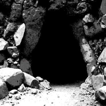 An eerie cave entrance with glowing crystals and ancient carvings