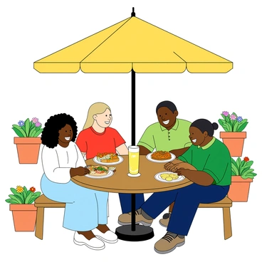 A group of four coworkers sitting at a round wooden table under a large yellow umbrella at an outdoor cafe. Two women and two men are present; one woman has curly black hair and is wearing a light blue dress, the other has straight blonde hair and is in a white blouse. One man has short brown hair and is wearing a red t-shirt, while the other has long black hair tied back and is in a green polo shirt. They are all smiling and laughing, sharing different colorful plates of food. A tall glass of lemonade with a slice of lemon is placed in front of each person on the table. The cafe is surrounded by vibrant flower pots and a few other tables with patrons enjoying their meals.