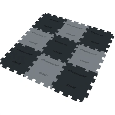 A gym floor covered with interlocking rubber mats in a grid pattern. The mats are in various shades of black and gray, featuring a textured surface that includes small grooves and raised patterns for traction. The overall layout shows the edges of each mat fitting snugly against one another, creating a seamless appearance. The lighting casts soft shadows, highlighting the texture and depth of the mats.